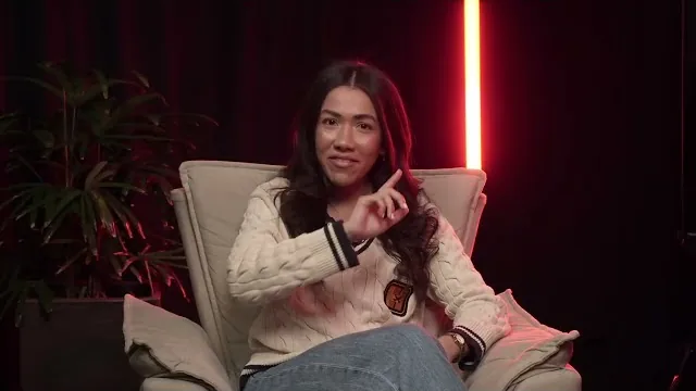 Elida Dias sentada em poltrona durante entrevista no podcast Por Trás do Sucesso